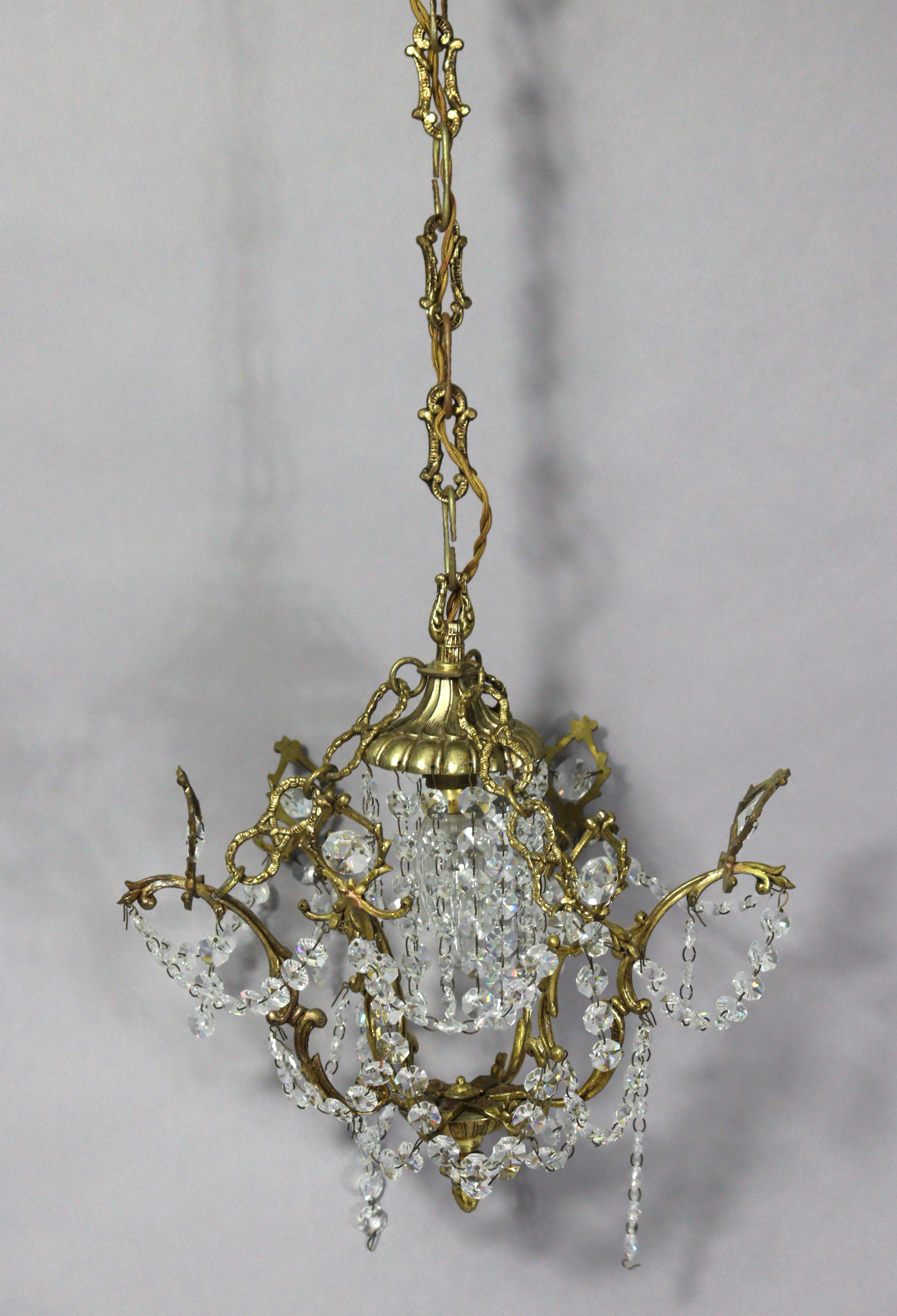 A bronzed metal five-Branch ceiling light fitting hung with cut-glass prism drops & strands-of-