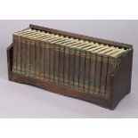 A set of twenty 1930s volumes “The New Punch Library”; together with an oak book-trough, 23¼” wide.