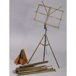 A vintage Maezel mahogany metronome, 9” high (w.a.f.); & three vintage metal sheet-music stands.