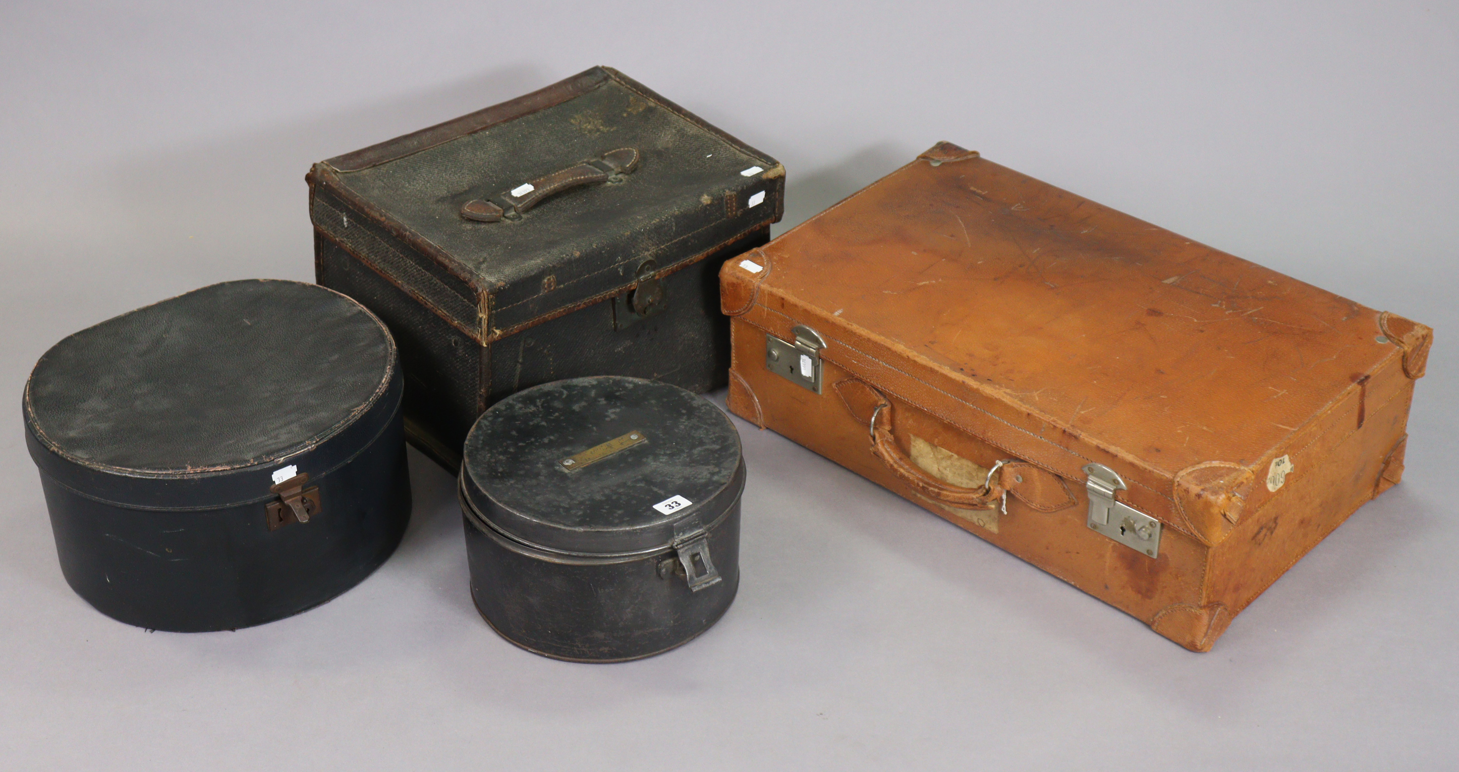 A vintage japanned-metal hatbox, 26.5cm diameter; together with another hatbox; a tan leather