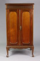 An Edwardian mahogany small upright cupboard with a blind fret-work frieze, having three shelves