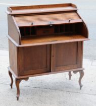 An early 20th century small oak writing desk with a fitted interior enclosed by a tambour shutter
