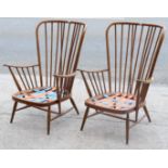 A pair of Ercol spindle-back armchairs (lacking cushions), on round tapered legs with spindle stretc