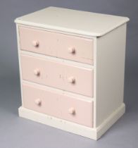 A white & pink painted pine small chest fitted three long drawers with turned knob handles, & on a