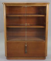 A mid-20th century abbess teak office side cabinet having two adjustable shelves enclosed by a
