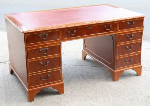 A reproduction yew wood pedestal desk inset gilt-tooled crimson leather, fitted with an