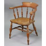 A vintage spindle-back captain’s chair with a hard seat, & on turned legs with spindle stretchers.