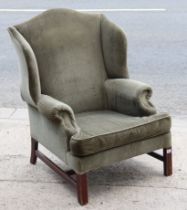 An early 20th century wing-back armchair upholstered grey material, & on short square legs with