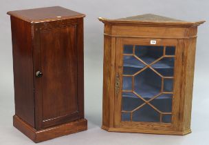 A pine hanging corner cabinet fitted two shaped shelves enclosed by a glazed door, 25¼” wide x