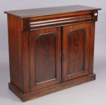 A Victorian mahogany dwarf cabinet having a centre shelf enclosed by a pair of panel doors, & on a
