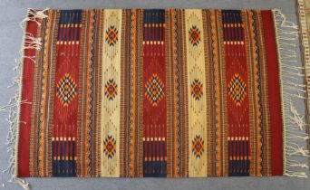 A kilim rug, a cow-hide rug, & three other modern rugs.