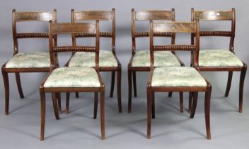 A set of six Victorian mahogany dining chairs with open splat backs, padded seats, & turned,