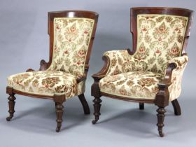 A pair of Victorian carved walnut ladies’ & gents’ easy chairs with velour upholstery, on turned