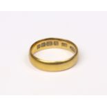 A 22ct. gold wedding band; size: L; weight: 4.5gm.