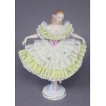 A Sitzendorf porcelain figure of a ballerina wearing white & yellow floral lace dress, on gilt