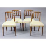A set of four early 19th century mahogany dining chairs with fluted back supports, padded seats &