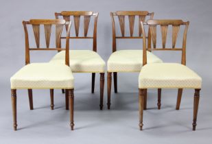 A set of four early 19th century mahogany dining chairs with fluted back supports, padded seats &
