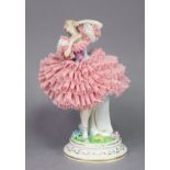 A Sitzendorf porcelain figure of a ballerina wearing pink lace dress, on floral-encrusted & gilt