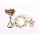 A 9ct. gold garland brooch set alternating peridot & seed pearls. 2cm dia. (2.7gm); in a small