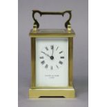 A modern English brass carriage timepiece with fluted corners, the white enamel dial with black