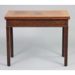 A George III mahogany tea table with fold-over top & blind fret-carved frieze, on square chamfered