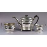 A George III silver matched four-piece tea service, each of oval shape with engraved foliate