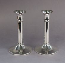 A pair of modern silver candlesticks with plain round columns & on slightly conical circular