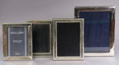 A modern silver plain rectangular photograph frame, 22cm x 17cm, Sheffield 1986; & three similar