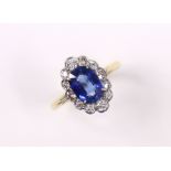 A SAPHIRE & DIAMOND RING, the oval-cut sapphire measuring approx. 9mm x 6.5 x 4mm, within a border