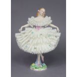A Sitzendorf porcelain figure of a ballerina, wearing white lace dress, on floral-encrusted circular