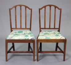 A pair of early 19th century inlaid mahogany dining chairs with shaped rail backs & padded drop-in