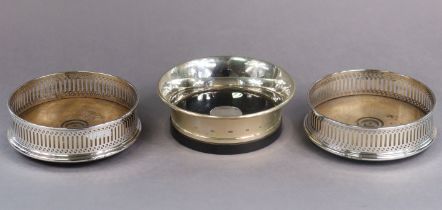 A pair of Georgian-style silver wine coasters with pierced sides &inset turned wooden bases, 12.3 cm