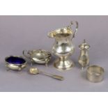 A George IV silver milk jug of inverted pear shape, with crimped rim, shaped loop handle, & on round