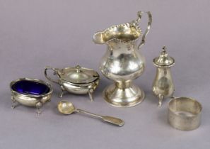 A George IV silver milk jug of inverted pear shape, with crimped rim, shaped loop handle, & on round