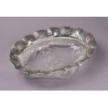 A late Victorian silver mounted cut glass oval dish, the wide silver rim with pierced trellis work &