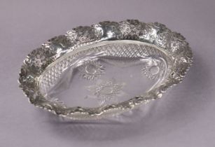 A late Victorian silver mounted cut glass oval dish, the wide silver rim with pierced trellis work &