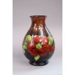 A Moorcroft pottery clematis pattern vase of baluster shape & of red/green flambe ground, 24cm high,