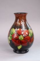 A Moorcroft pottery clematis pattern vase of baluster shape & of red/green flambe ground, 24cm high,