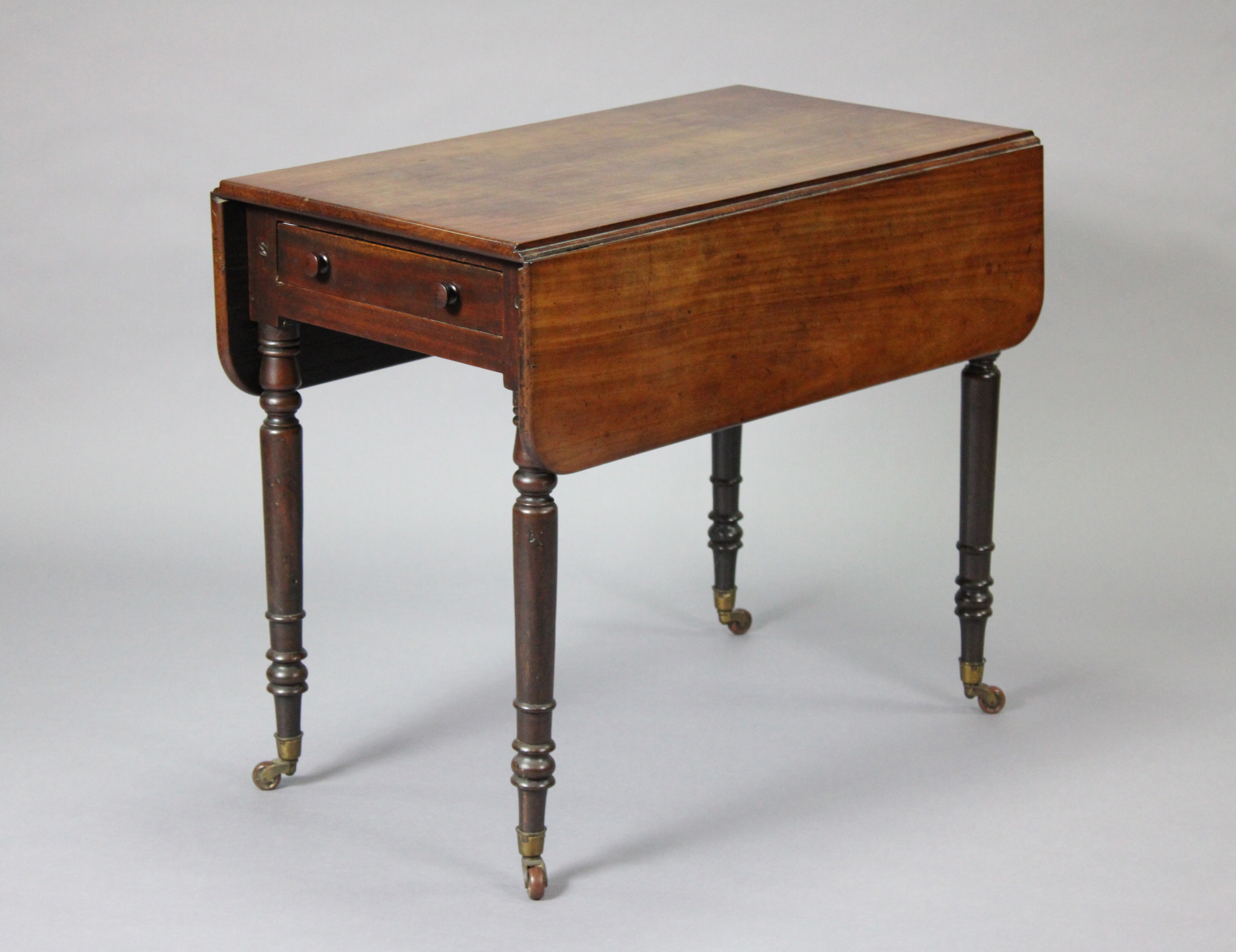 A Victorian mahogany Pembroke table, fitted with a drawer to one end, on turned tapering legs with