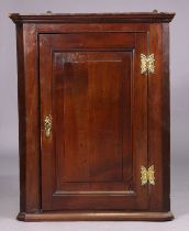 A Georgian fruitwood hanging corner cupboard fitted with three shaped shelves enclosed by a