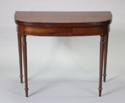 A regency inlaid mahogany bow-front card table with hinged fold-over top, on slender turned tapering