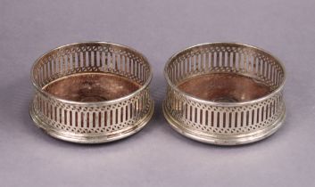 A pair of modern silver wine coasters with pierced straight sides, each inset turned wood base,