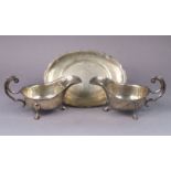 A pair of George VI silver oval sauce boats with cut-card rims, each with c-scroll handle & on three