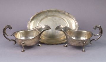 A pair of George VI silver oval sauce boats with cut-card rims, each with c-scroll handle & on three