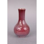 A Chinese porcelain peachbloom-glazed small bottle vase, with slightly flared neck & on short