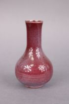 A Chinese porcelain peachbloom-glazed small bottle vase, with slightly flared neck & on short