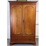 An 18th century-style mahogany two door wardrobe with a moulded dentil cornice above a hanging