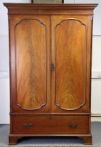 An 18th century-style mahogany two door wardrobe with a moulded dentil cornice above a hanging