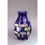 A Moorcroft pottery Pansies pattern baluster vase of deep blue ground, 24cm high, impressed