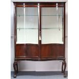 A late Victorian mahogany serpentine-front glazed display cabinet, fitted two glass shelves, with